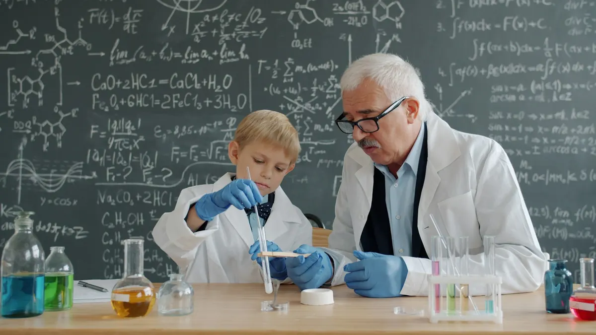 A scientist and a young boy in lab coats carry out a chemistry experiment with test tubes